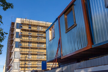 Construction trailer against the background of an apartment building under construction