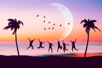 Fototapeta na wymiar Silhouette happy friends jumping on sunset sky at tropical beach with palm tree and birds flying abstract background. Copy space of feel good freedom and travel adventure concept.