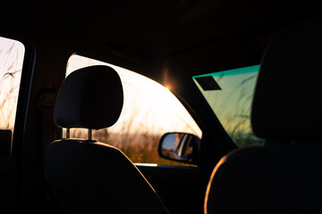 Abstract relax scene of silhouetted car seat with sunrise.