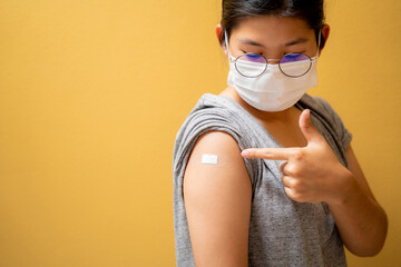 Close up of happy teens girls and wear a mask in the shoulder with plaster on arm after vaccination...
