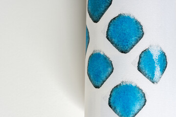 rolled paper, featuring rounded square shapes in blue and black on white