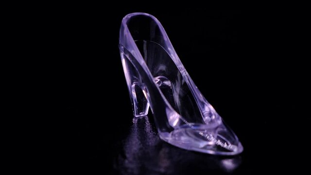 Rotating crystal or transparent glass slipper on black background Cinderella concept