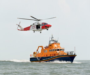 Orange sea rescue boat with rescue helicopter