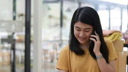Fototapeta premium Young women talking on phone with a smiling expression.