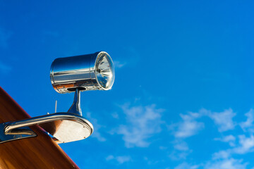 Stainless steel floodlight on the yacht hull close-up.