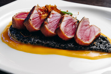 Tataki tuna fillet with black risotto and mango sauce