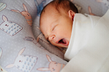 The newborn baby sleeps and yawns. healthy children's sleep. 