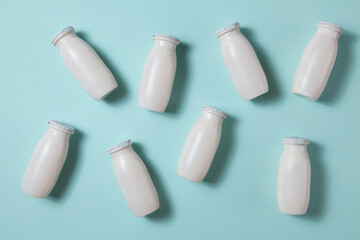 Bottles with probiotics and prebiotics dairy drink on light blue background.