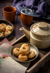 Indian traditional sweet balushahi served on a metal plate on wooden background