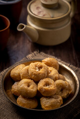 Indian traditional sweet balushahi served on a metal plate on wooden background