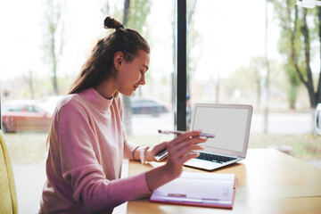 Satisfied female freelancer working on project in cafe