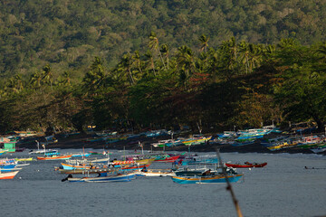 Fototapeta premium Dozens of colorful fishing boats moored near the beach, Tangkoko Nature Park, Sulawesi, Indonesia