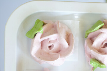 Homemade marshmallows. Zephyr of different shapes, in the form of rose flowers. Lies on a white surface.