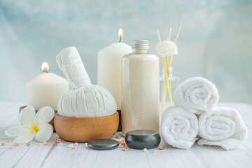 Fototapeta na wymiar Natural relaxing spa composition on massage table in wellness center with towels, flowers and salt, candle on massage table in spa salon.