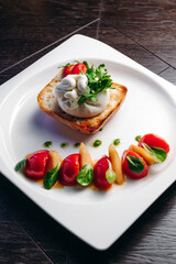 Salad with Tomatoes, honey pear and Burrata cheese with basil and olive oil on wooden background