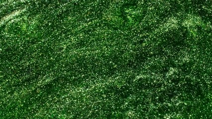 Macro shot of liquid golden green glitter in a loop