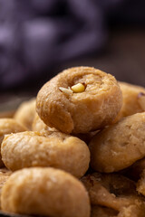 Indian traditional sweet balushahi served on a metal plate on wooden background