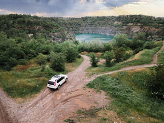 top view of suv car on path road to mine flooded lake