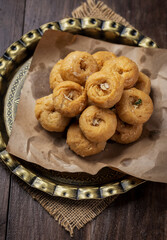 Indian traditional sweet balushahi served on a metal plate on wooden background