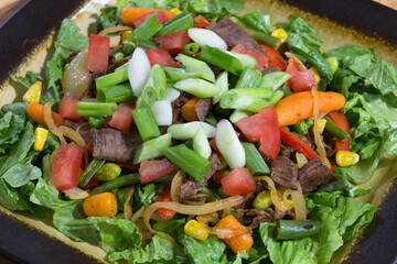  stir fried beef and vegetables on salad greens