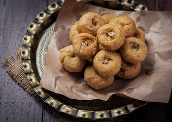 Indian traditional sweet balushahi served on a metal plate on wooden background