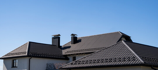 Brown corrugated metal profile roof installed on a modern house. The roof of corrugated sheet....
