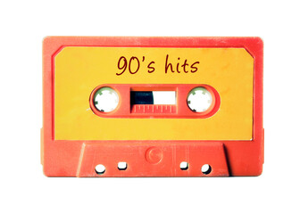 An old vintage cassette tape (obsolete music technology) with the handwritten text: 90's hits. Light red plastic body, vivid orange label, isolated on white.
