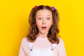 Portrait of attractive amazed brown-haired girl good news reaction isolated over bright yellow color background