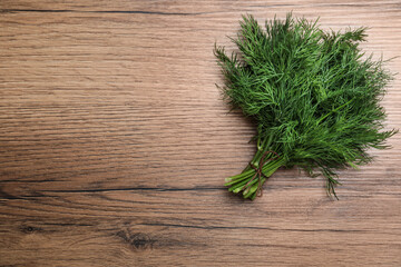 Bunch of fresh dill on wooden table, top view. Space for text