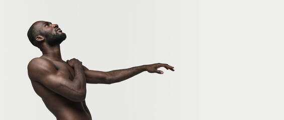 Flyer. Young handsome muscled African man posing isolated over white background. Concept of beauty.