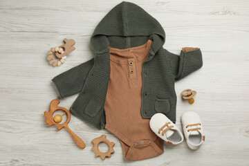 Flat lay composition with baby clothes and accessories on white wooden table