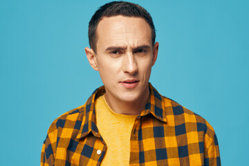 man in plaid shirt on blue background emotions cropped view