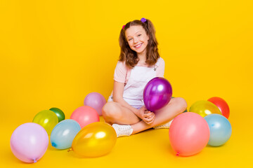 Fototapeta na wymiar Full length body size photo schoolgirl at party with balloons smiling happy isolated vibrant yellow color background