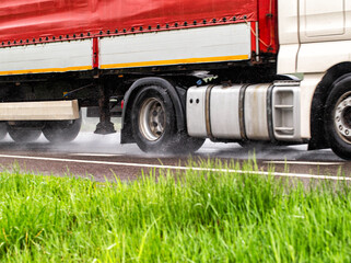 Truck tires in wet weather on wet asphalt. Wet weather road safety concept. Braking distance and...