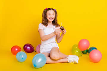 Full length body size photo schoolgirl at party smiling keeping cupcake with candles isolated...