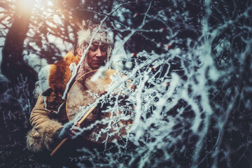 beautiful shamanic girl playing on shaman frame drum in the nature.
