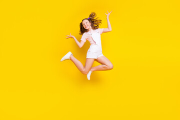 Fototapeta na wymiar Full length body size view of attractive cheerful girl jumping fooling rest holiday isolated over bright yellow color background