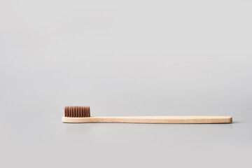 Ecology toothbrush. Sustainable mouth product. Zero waste lifestyle. Organic accessory. Dental health at home. Biodegradable recycle. Grey background. Copyspace. Brow color