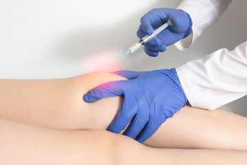 The doctor injects an ozone-oxygen mixture into the patient's knee joint to relieve muscle spasm and inflammation. Ozone therapy, copy space for text - obrazy, fototapety, plakaty