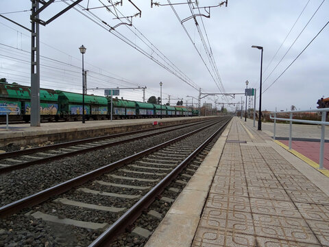 merchandise train station. View of train tracks with rails and freight wagons with power lines