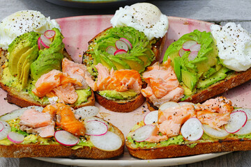 A healthy lunch of avocado toast with salmon and poached egg