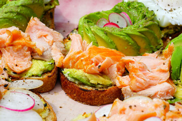 A healthy lunch of avocado toast with salmon and poached egg