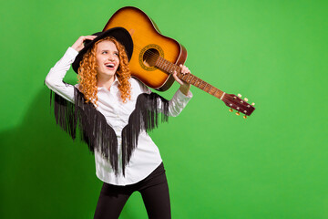 Portrait of attractive cheerful girl holding guitar posing good mood having fun rock event isolated over bright green color background