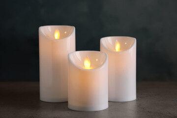 Fototapeta na wymiar Beautiful decorative LED candles on grey table