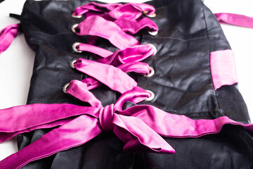 Pink Cord In Fashionable Black Lace Up Dress, macro. Background