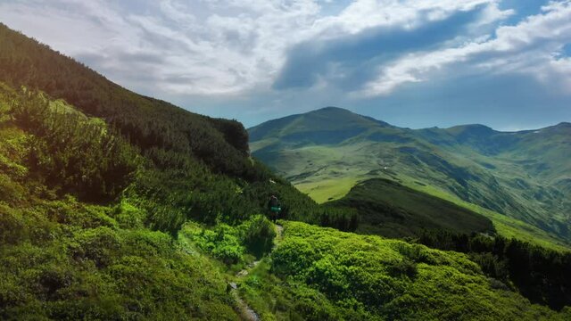 Hiker woman on mountain path aerial drone footage on a trail in Romania