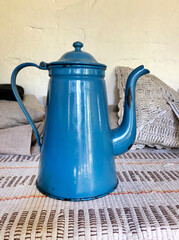 Blue enamel metal vintage coffee pot in a rustic interior
