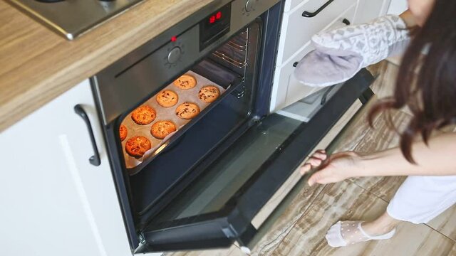 woman baking cookies in the oven