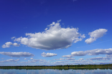 Blue sky with clouds and a beautiful river and forest