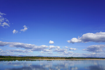 Blue sky with clouds and a beautiful river and forest